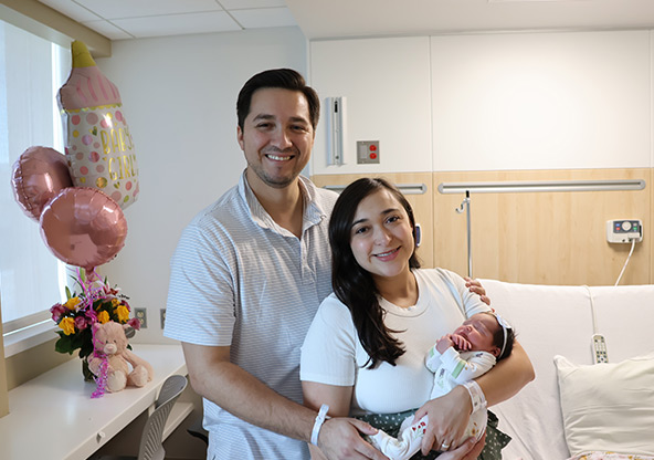 Cecilia, her husband, Jorge, and their new baby Isabella in their hospital room after delivery